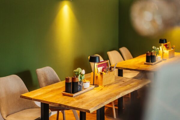 Liebevoll dekorierte Tische und eine geschmackvolle Wandgestaltung in grün und cremeweiß verleihen dem Restaurant auf der Harz-Urlaubs-Alm eine einladende Atmosphäre.